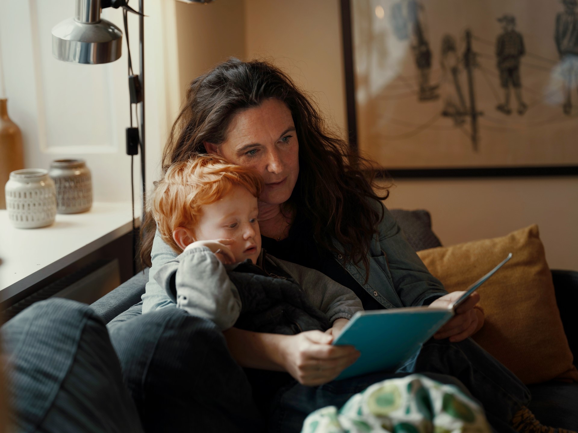 Woman reading a book to a child.